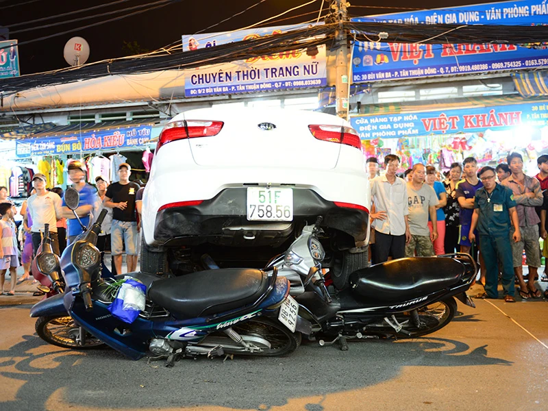 Chiếc xe ô tô đang lùi thì cuốn 6 xe máy vào gầm trên đường Bùi Văn Ba (quận 7, TP.HCM).